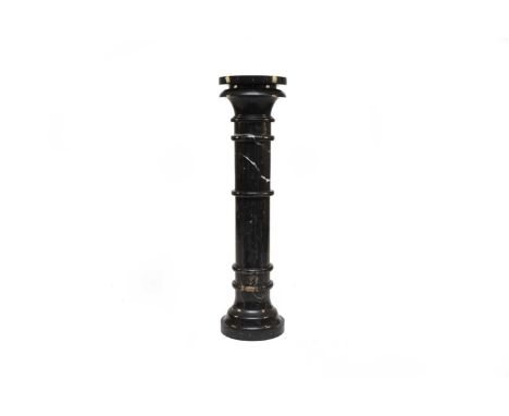 A dark grey veined Sienna marble pedestal or torchère standWith Egyptian style capital, multi-knopped trunk and ogee foot.99.