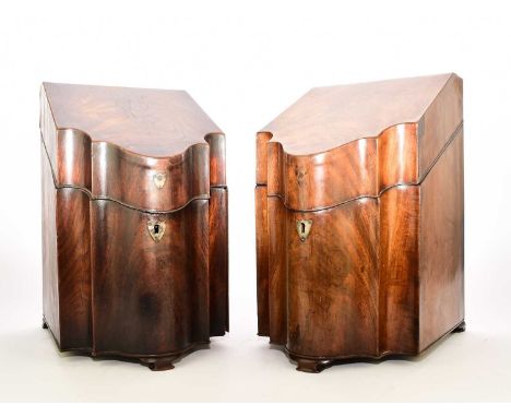 A pair of George III mahogany knife boxesOf typical serpentine form, raised on ogee bracket feet, with fitted interiors.23cm 