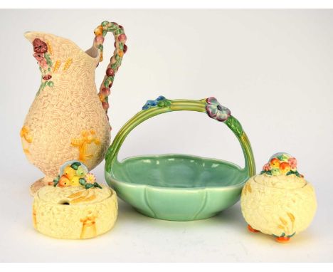 A group of Clarice Cliff comprising a ‘Celtic Harvest’ jug, 27.8cm high, a jam pot and preserve jar, 9cm and 12cm high, toget
