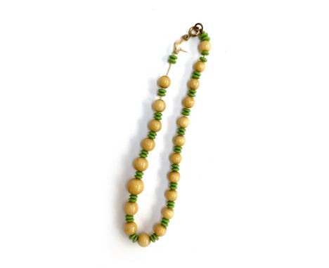 A russet jade and green glass bead necklace in need of restringing 