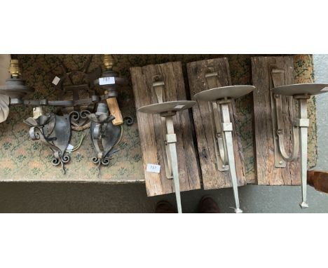 Three wrought metal candle wall sconces; together with two two wrought iron sconces with electrical fittings, and a two arm w