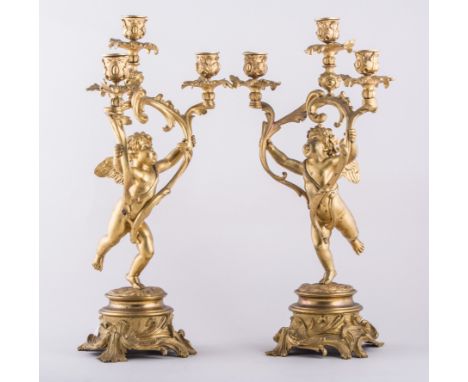 Pair of Louis Philippe style gilt metal three light candelabra, modelled with cherubs, circular bases, 45cm.