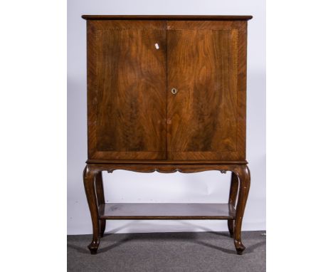 Chillean rosewood cocktail cabinet on stand, two doors enclosing a lined fitted interior, open under shelf, scrolled suppport