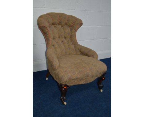 A VICTORIAN UPHOLSTERED BEDROOM CHAIR with a shaped back on scrolled cabriole front legs and ceramic casters