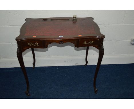 AN EDWARDIAN MAHOGANY LADIES DESK with a red tooled leather inlay top, one inkwell, two small drawers, on cabriole legs with 