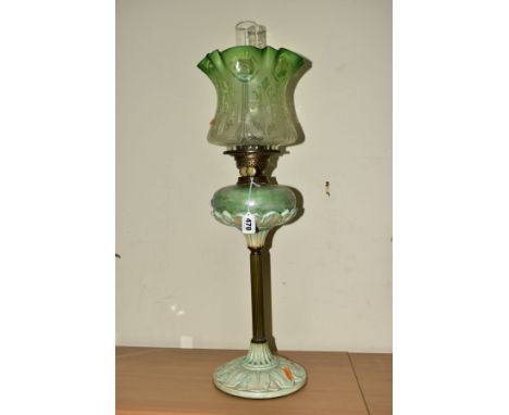 A LATE 19TH CENTURY OIL LAMP, wavy green, opaque and clear acid etched shade, iridescent and pale green glazed ceramic and gl