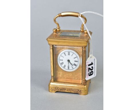 A LATE 19TH/EARLY 20TH CENTURY GILT METAL CARRIAGE CLOCK OF SMALL SIZE, engraved decoration to the case, white enamel dial wi