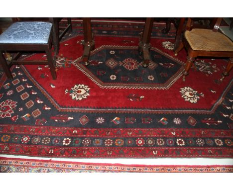A LARGE BURGUNDY GROUND TURKISH CARPET, with large centre medallion, with stylised flowers and birds, inside a four-band bord