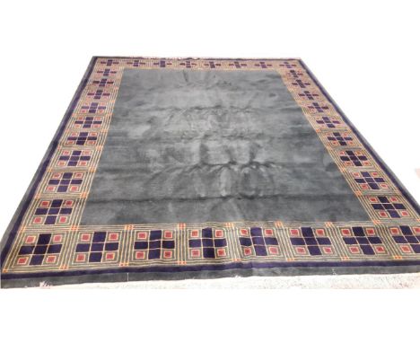 AN ART DECO STYLE GREEN WOOL CARPET, the wide border with panels of squares, inside a dark blue band, 119" (302cm)h x 94" (23