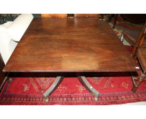 A REGENCY PERIOD MAHOGANY DINING TABLE, with square top, on a ring turned stem, with quadruple pod, with heavy splayed legs a