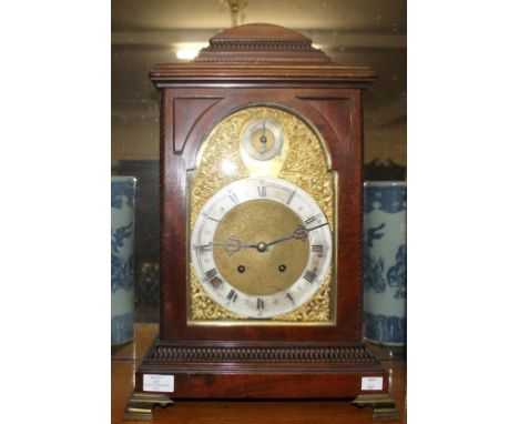 A GEORGIAN STYLE MAHOGANY AND BRASS-MOUNTED BRACKET CLOCK, c.1900, the domed and reeded top above an arched glass dial, with 