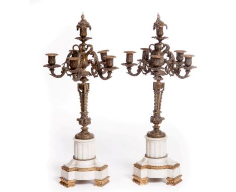 A PAIR OF GILT BRASS AND WHITE MARBLE FIVE-BRANCH, SIX-LIGHT CANDELABRA, each with leaf cast scrolling arms, and urn-shaped s