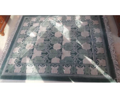 A GOOD HEAVY WOOL RUG, in the William Morris style, with rows of leaf sprays, in light green and ivory, inside a conforming l