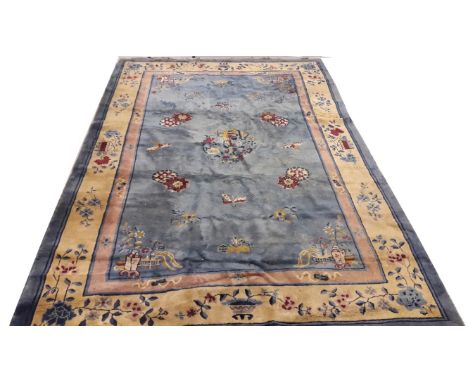 A CHINESE LIGHT BLUE GROUND WOOL CARPET, the field with stylised flowers, and butterflies, inside a three band conforming bor