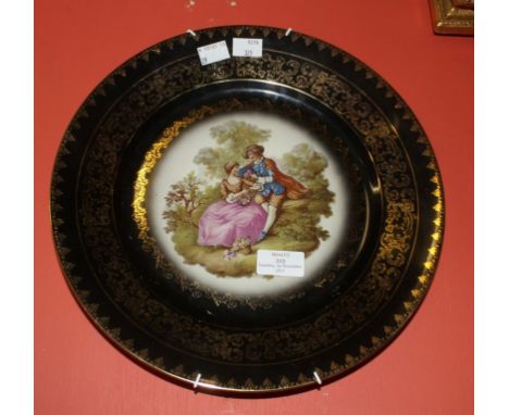 A PAIR OF VIENNA STYLE PORCELAIN CABINET PLATES, each decorated with a couple in a garden, against a black ground with gilt s