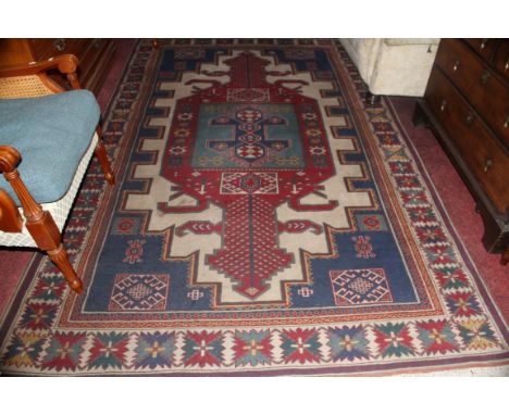 A LARGE TURKISH RUG, with light blue and red medallion, within dark blue stepped spandrels, inside an ivory border with styli