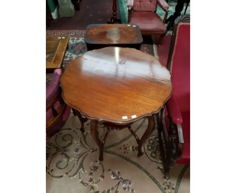 AN EDWARDIAN WALNUT CENTRE TABLE, with circular moulded serpentine shaped top, above a conforming stretcher shelf and raised 
