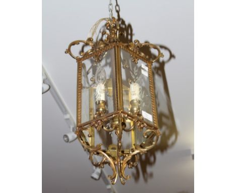 A HEXAGONAL BRASS LANTERN, in the late eighteenth century style, with five glazed panels and three-branch light fittings, 23"