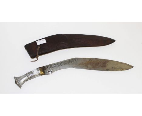 AN INDIAN GURKHA KNIFE, in moulded leather scabbard. (1) 