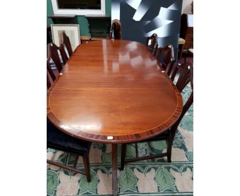 A REGENCY STYLE INLAID AND CROSS-BANDED MAHOGANY DINING TABLE, O.R.M., with two tripod pedestals with reeded legs and lion br