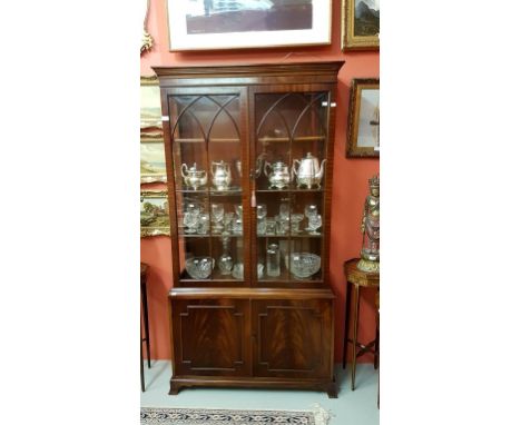 A MAHOGANY DISPLAY CABINET IN THE GEORGE IIII GOTHIC STYLE, the moulded cornice above two glazed doors, and two panels doors 