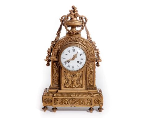 A FINE FRENCH GILT BRASS MANTEL CLOCK, nineteenth century, the arched case surmounted with an urn packed with fruit and flowe