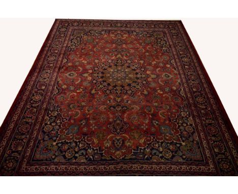 A LARGE BURGUNDY GROUND PERSIAN MASHAD CARPET, with centre circular star medallion on a burgundy ground with all-over floral 