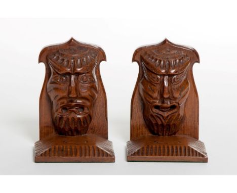 TWO PAIRS OF UNUSUAL ARTS AND CRAFTS CARVED OAK BOOK RESTS, each with a grotesque mask, on a shaped bracket and square fluted