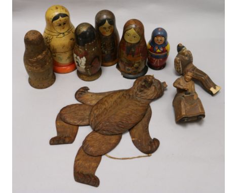 A Black Forest Bear string puppet, various Russian dolls and two carved figures