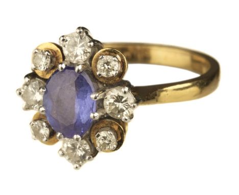 * Ring. An 18ct gold sapphire and diamond cluster ring, the central sapphire surrounded by 8 diamonds each set in a claw, sta