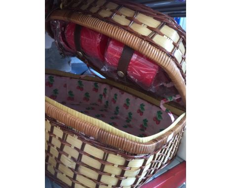 A wicker picnic hamper with plates and cups 