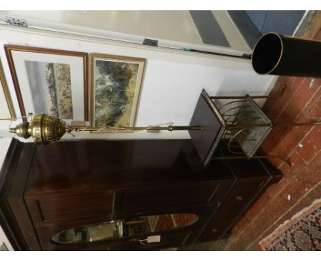 A 20th century brass telescopic standard lamp, with magazine rack, raised on splayed legs.