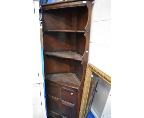 A vintage dark stained Ercol style corner shelf with cupboard under