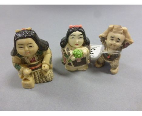 Three netsuke style carvings to include two girls and a boy with books on head