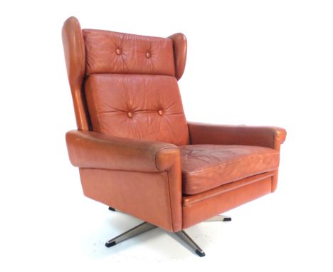 A Skippers Mobler tan leather and button upholstered wingback armchair on an aluminium five star base   CONDITION REPORT:  So