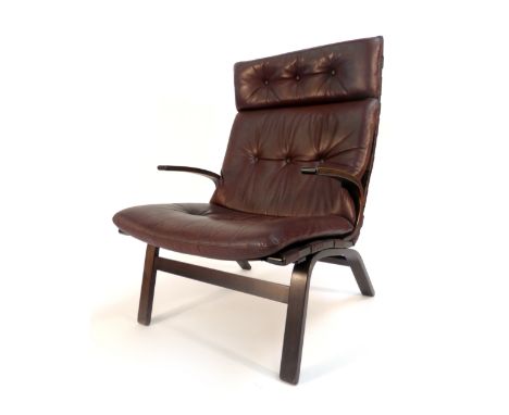 A 1970's brown button upholstered high-back armchair on a laminate frame   CONDITION REPORT:  Wear commensurate with age, som