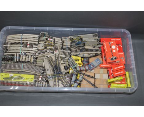 A plastic container of Marklin HO scale track sections, switching points, signals, and other accessories, boxed and un-boxed