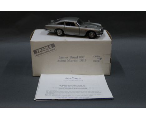 A Danbury Mint 1:24 scale detailed diecast model of a James Bond 007 Aston Martin DB5, keeping its original cardboard box and