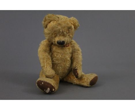 A 1930's Chad Valley Teddy Bear, having blonde mohair covered body, vertically stitched nose, having a blue cloth label stitc