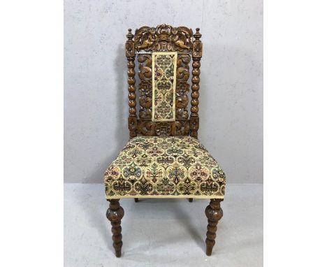 Gothic style heavily carved chair with bobbin turned legs and supports and floral carvings with tapestry seat and back rest