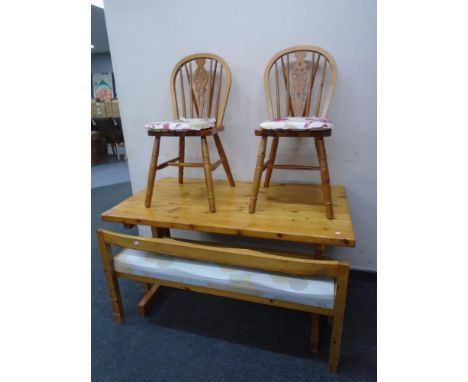 A pine refectory table together with a pair of wheelback chairs and a bench.