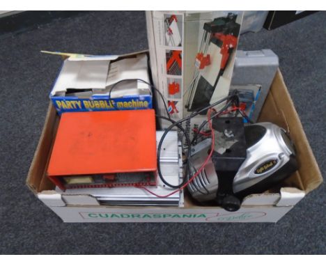 A box containing a tile cutter, a bubble machine, a soldering kit, a light splash, battery charger etc.