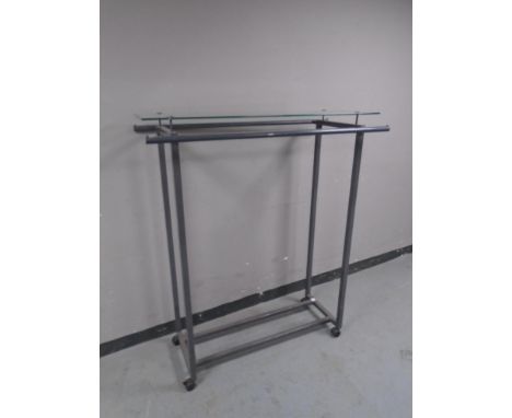 A twin sided portable metal clothes rail with glass shelf.