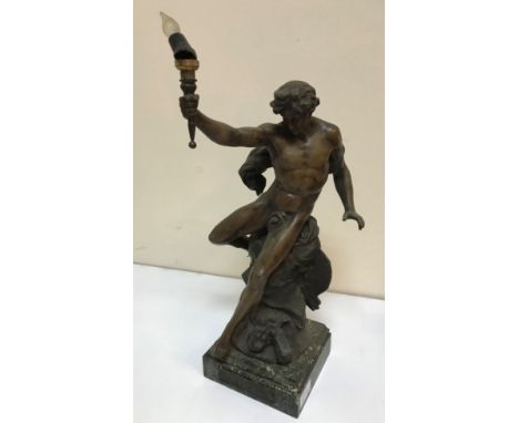 A 19th Century spelter table lamp in the form of a male nude on rocky outcrop holding aloft a torch, raised on granite base, 