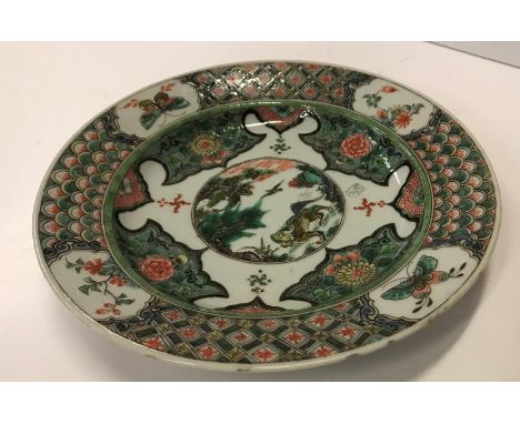 A Chinese Kangxi famille verte plate, the centrefield decorated with kylin in a landscape and Swastikas, within a stylised dr