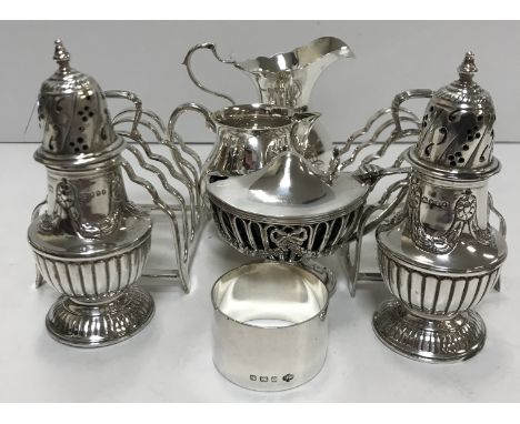 A collection of small silver wares to include a pair of peppers, pedestal lidded mustard with blue glass liner, two cream jug