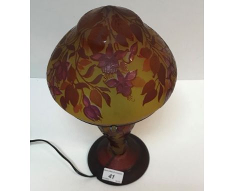 A 20th Century cameo glass lamp in the manner of Gallé with all over floral decoration in red on a yellow ground bearing name