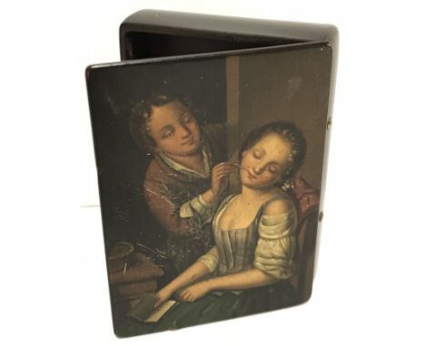 A 19th Century lacquered papier-mache snuff box depicting “Young man tickling a sleeping girl, a book in her hand”, 7 cm long
