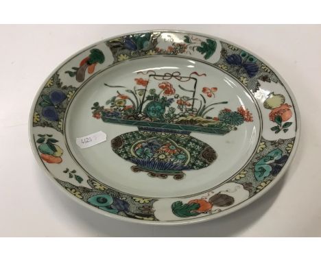 A Chinese Kangxi famille verte plate, the centre field decorated with polychrome vase of flowers within a butterfly and flowe