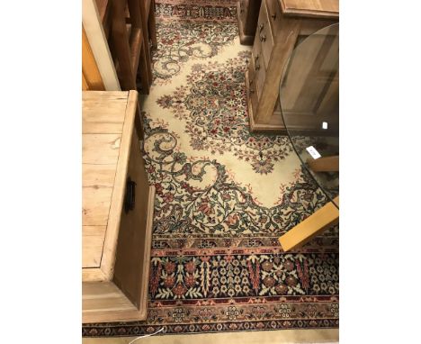 A machine woven Persian carpet, the central panel set with floral decorated medallion on a pale green ground, within a steppe